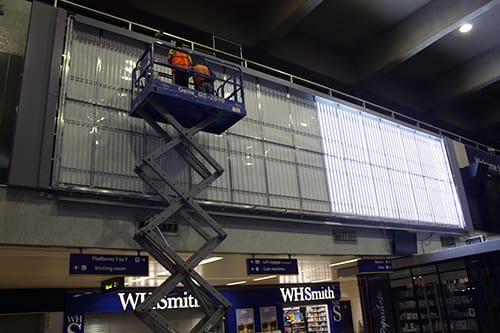 Close-up of an LED matrix installation in progress, showcasing rows of small, bright LED lights being securely attached to a frame. The LEDs are arranged in a grid pattern, highlighting the precision and technology involved in modern LED lighting systems.