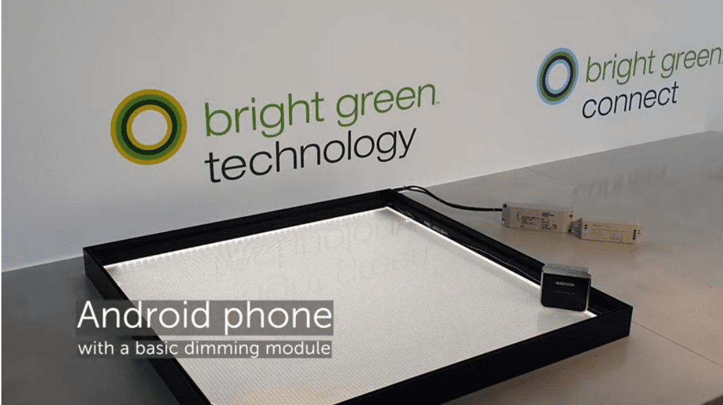 A Bright Green Technology display frame sits on a reflective surface, connected to a dimming module labeled "Android phone with a basic dimming module." The background features Bright Green Technology's logo, the text "Bright Green Connect," and highlights the advanced lighting control capabilities.