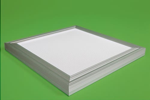 A stack of metallic air filters with white mesh center, resting on a green background. The filters have a rectangular shape with a silver frame and multiple layers visible from the side.