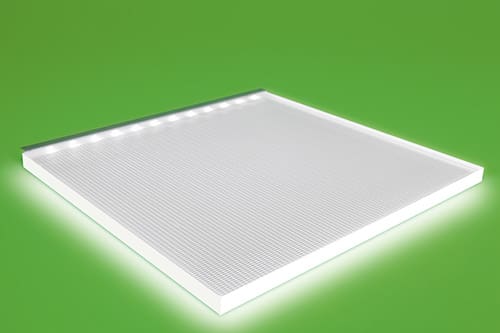 A rectangular LED panel light with a white surface and a strip of small lights along one edge. The panel is illuminated and resting on a bright green background.