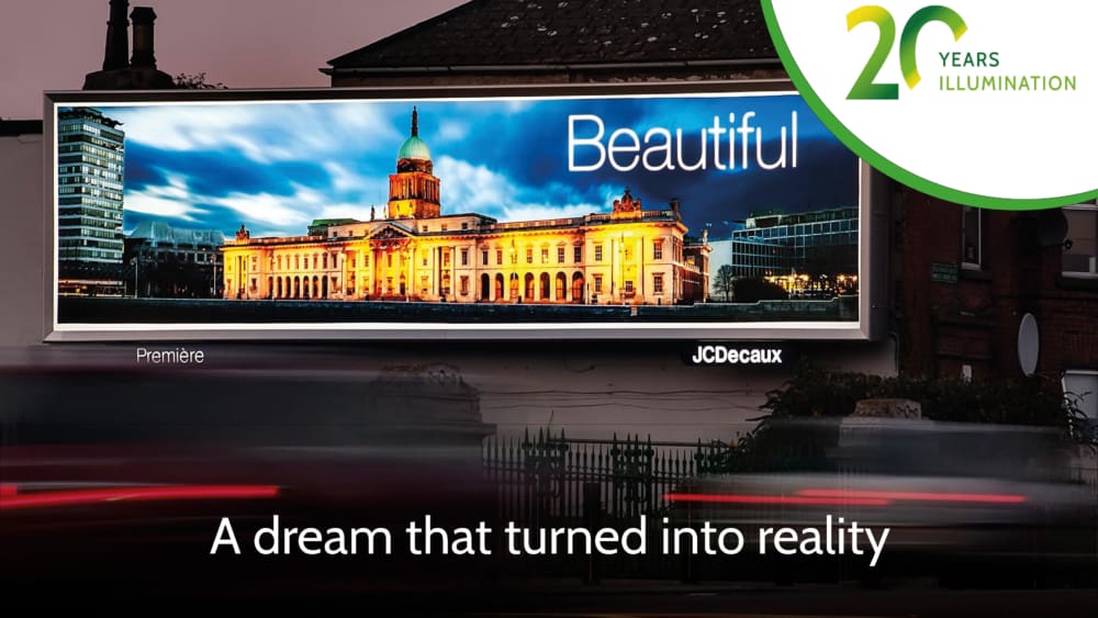 A large, backlit illuminated billboard at night showcases a beautifully lit historic building with a dome. The LED backlit display proudly reads "Beautiful" with the text below stating, "A dream that turned into reality." In the top right corner, a logo celebrates "20 Years Illumination.