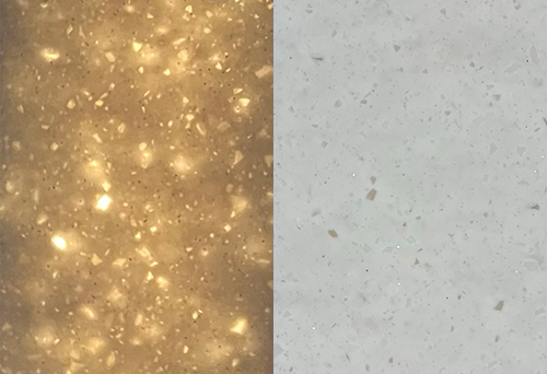 A split image of two surfaces: the left side is speckled with glowing, warm-toned flecks, resembling a golden terrazzo. The right side reveals backlit surfaces in a muted, light gray with subtle speckles, appearing smoother and less reflective.